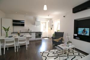 a kitchen and living room with a table and a tv at Carrera Corner Apartment in Rovinj