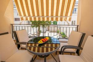 - une table avec un bol de fruits sur le balcon dans l'établissement Kristal Apartmani, à Čanj