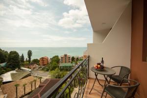 a balcony with a table and chairs and a view of the ocean at Tamari in Kvariati