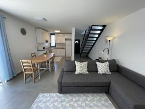 a living room with a couch and a dining room at Vila Flor - Vilamoura in Vilamoura