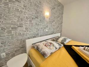 ein Schlafzimmer mit einem Bett mit Ziegelwand in der Unterkunft Apartments King - City center in Novalja