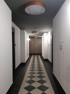 un couloir avec un sol en damier et un plafond dans l'établissement Mazowiecka Park, à Kołobrzeg