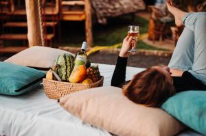 a woman holding a glass of wine and a basket of fruit at City Villa in Arusha