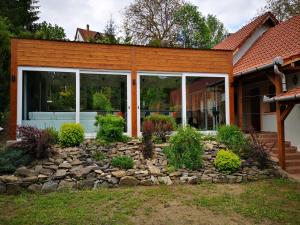 una casa con un jardín de rocas delante de ella en Nyitott Kapu Vendégház, en Felsőtárkány