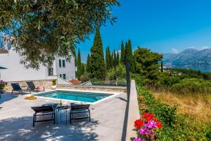 a house with a pool and a view of the water at Apartments Aldo in Cavtat