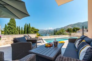 a patio with a table and chairs next to a swimming pool at Apartments Aldo in Cavtat