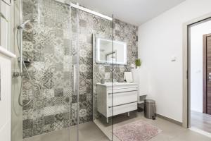 a bathroom with a shower with a sink and a mirror at Apartments Aldo in Cavtat