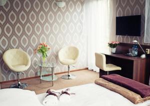 1 dormitorio con 1 cama, 2 sillas y escritorio en Makara, en Katowice