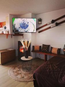 sala de estar con TV y chimenea en Appartement 8 couchages 45 m2 tout confort à la foux d'allos en La Foux