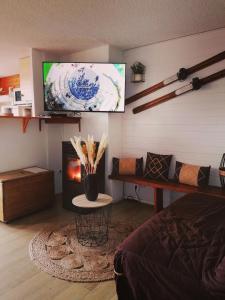 ein Wohnzimmer mit einem TV und einem Kamin in der Unterkunft Appartement 8 couchages 45 m2 tout confort à la foux d'allos in La Foux