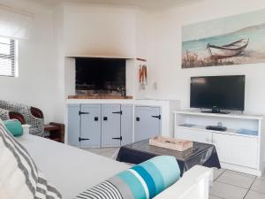 een woonkamer met een bed en een flatscreen-tv bij Pearly Gate in Pearly Beach