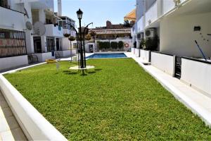 een binnenplaats in een gebouw met een tuin met gras bij Oasis Torremolinos in Torremolinos