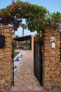 uma entrada para uma casa com um portão e uma parede de pedra em Villa Amira em Custonaci