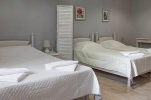 a bedroom with two beds and a mirror at Narkissos 'SUPERB' in Chania