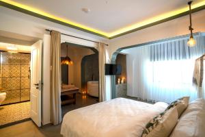 a bedroom with a large bed and a bathroom at Liman Hotel Gümüslük - Adult Only in Bodrum City