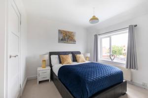 a bedroom with a blue bed and a window at Modern Three Bedroom Home in Gloucester with Hot Tub in Gloucester