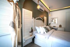 a bedroom with a white bed and a window at Liman Hotel Gümüslük - Adult Only in Bodrum City