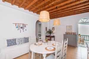 a dining room with a white table and chairs at Charming House Platy Gialos in Platis Gialos