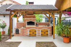 an outdoor brick oven with a roof on top at Vila Coty in Mamaia Nord