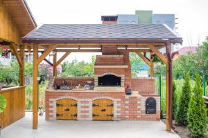 an outdoor kitchen with a roof on a brick oven at Vila Coty in Mamaia Nord