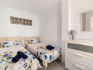 een slaapkamer met 2 bedden en een dressoir bij Oasis Torremolinos in Torremolinos