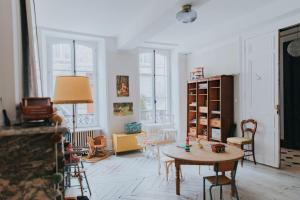 a living room with a table and some chairs at Maison Séraphine - Guest house - Bed and Breakfast in Laon