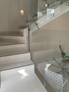 una camera con tavolo in vetro e scale di Casa Vacanze Le Palette - Glicine a Ponza
