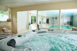 a large bath tub in a room with a swimming pool at VILLA VARENTIA in Villers-Bretonneux