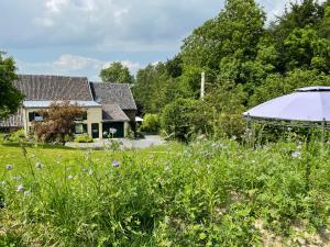 uma casa com um jardim e um telhado branco em Bellerose Maison de Greunebennet em Plombières