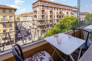 balcone con tavolo, sedie e vista sulla città di Hotel America a Milano
