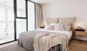 a bedroom with a large bed and a large window at ZETU The Dunes in Knokke-Heist