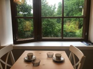 a table with three cups on it in front of a window at Mathildedal Private Apartments in Matildedal