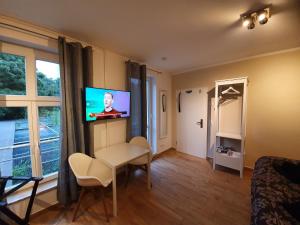 a living room with a television and a table and chairs at Papageiennest in Dresden