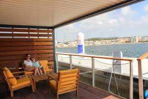 un homme et une femme assis sur le pont d'un bateau dans l'établissement Les Ilots de Gruissan, à Gruissan