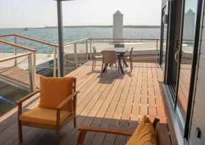 - un balcon avec une table et des chaises sur un bateau dans l'établissement Les Ilots de Gruissan, à Gruissan