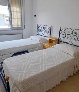 dwa łóżka siedzące obok siebie w pokoju w obiekcie Donatella Mare w mieście Tortoreto Lido