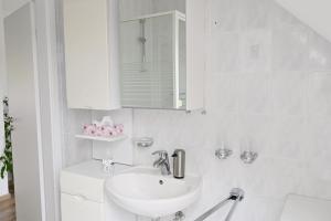 a white bathroom with a sink and a mirror at Fewo, Nähe Dieksee in Malente