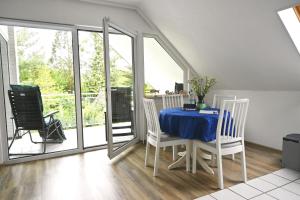 uma sala de jantar com uma mesa azul e cadeiras em Fewo, Nähe Dieksee em Malente