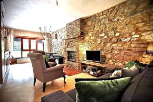 sala de estar con pared de piedra en Out & LODGE Prunelliers, en Couvin