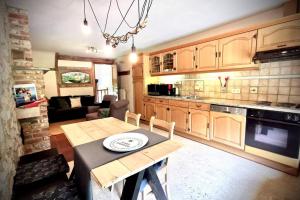 a kitchen and living room with a table and a couch at Out & LODGE Prunelliers in Couvin