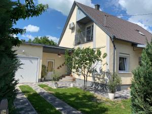 a white house with a garden in front of it at Marci Apartman in Balatonboglár