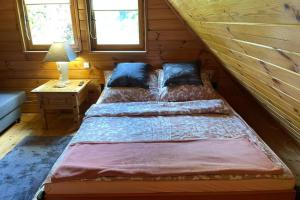 SitnoにあるDomek w Sitnieの丸太小屋のベッドが2つある寝室