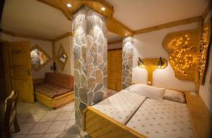 a bedroom with a bed and a stone wall at Hotel & Restaurant Elbschetal in Wetter