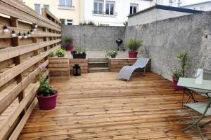 ブレストにあるJoli appartement avec jardin-terrasse privéの木製の床と植物のある屋外パティオ
