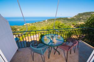 a balcony with a table and chairs and the ocean at Elena Studios in Athani