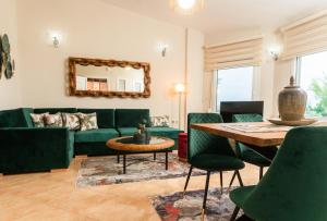 a living room with a green couch and a table at Aelia Villa Leptokarya in Plaka Litochorou