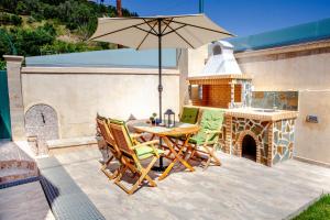 a patio with a table and chairs and an umbrella at FilipposResort in Agios Gordios