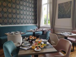 a dining room with tables and chairs with food on them at VILLA VARENTIA in Villers-Bretonneux