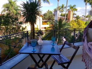 a blue table with two vases on a balcony at Flat Bairro Nobre - Bertioga in Bertioga