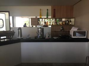 a kitchen with a counter top with a microwave at IPÊ PLAZA HOTEL LTDA in Itumbiara